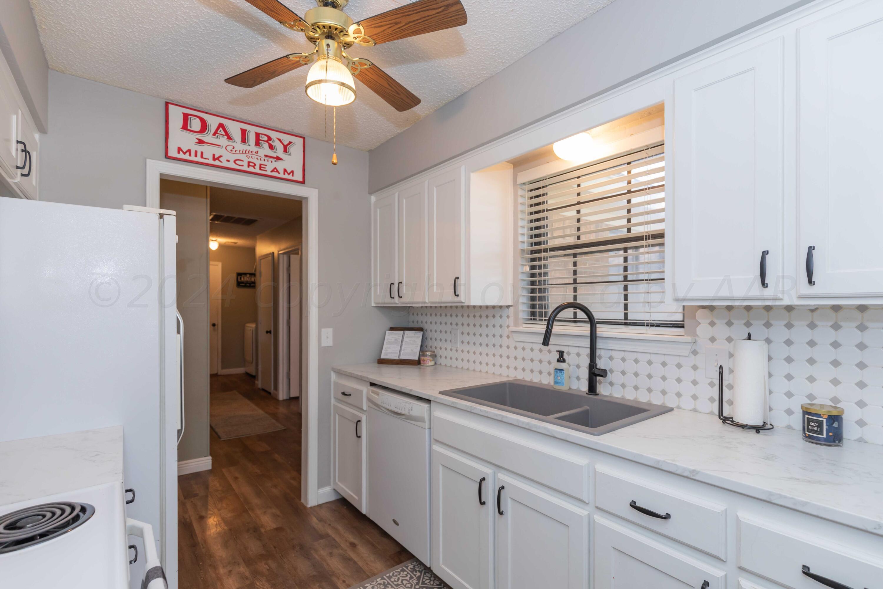 5804 Oakman Drive Amarillo, TX 79109 - Photo 15 of 48 a kitchen with a sink cabinets and a window