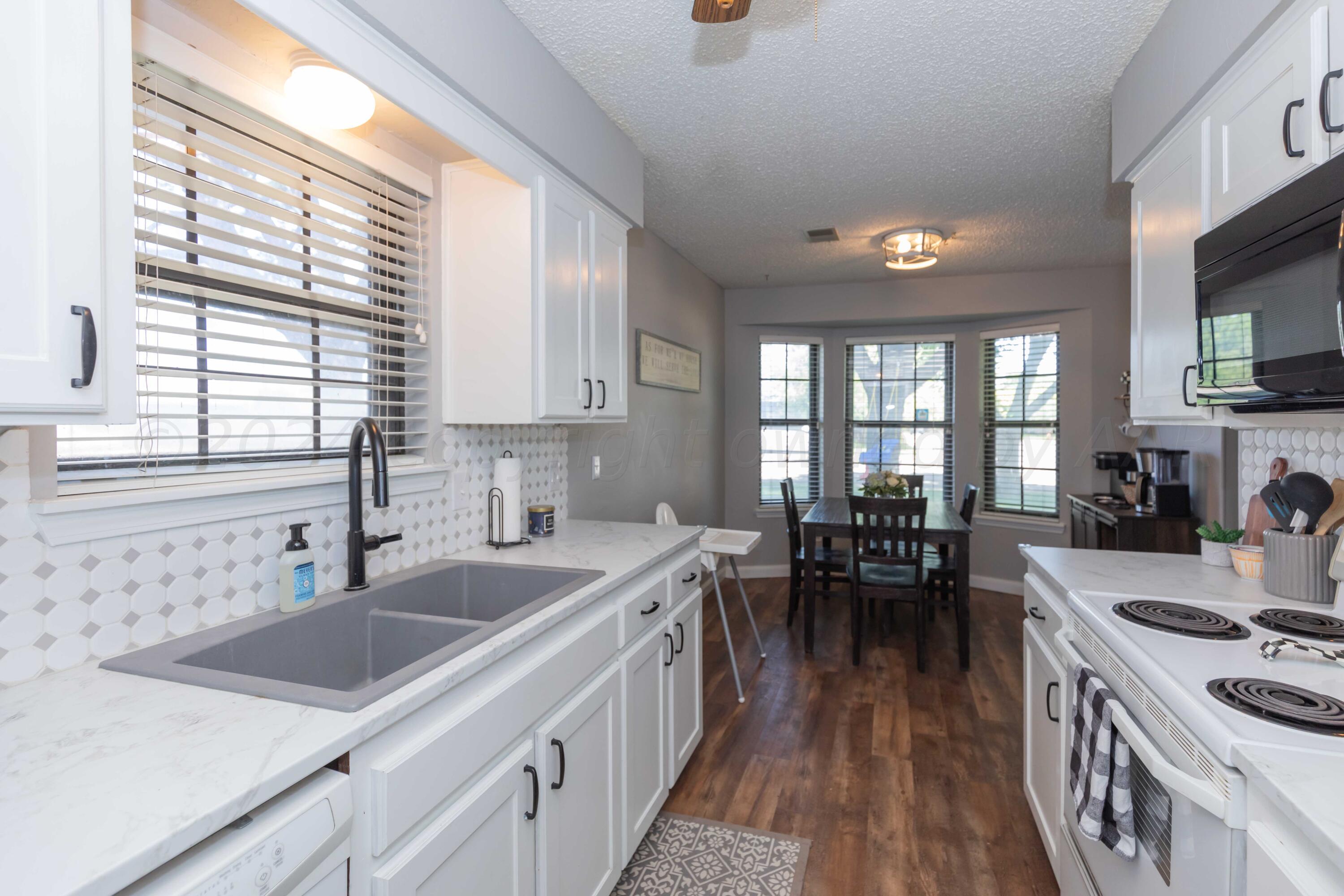 5804 Oakman Drive Amarillo, TX 79109 - Photo 16 of 48 a kitchen with a sink stove and cabinets