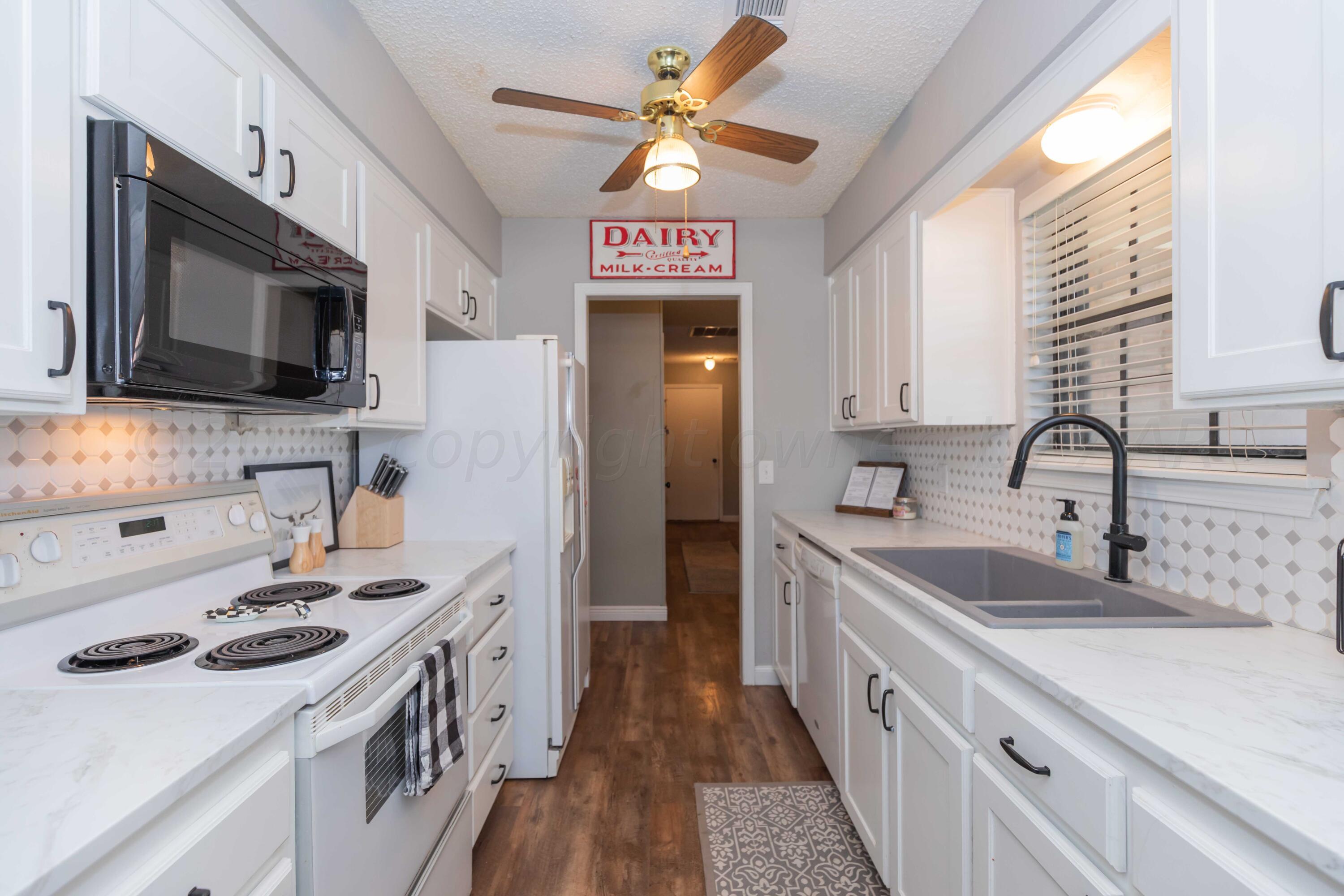 5804 Oakman Drive Amarillo, TX 79109 - Photo 17 of 48 a view of a kitchen with a sink and a microwave