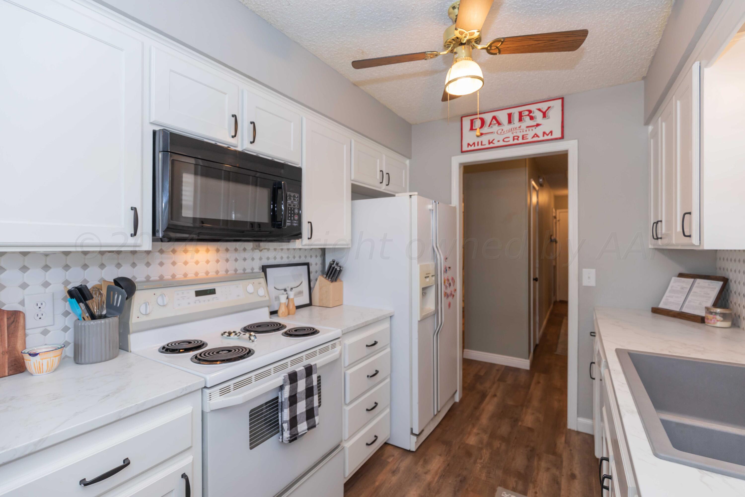 5804 Oakman Drive Amarillo, TX 79109 - Photo 18 of 48 a kitchen with stainless steel appliances a stove microwave and a refrigerator