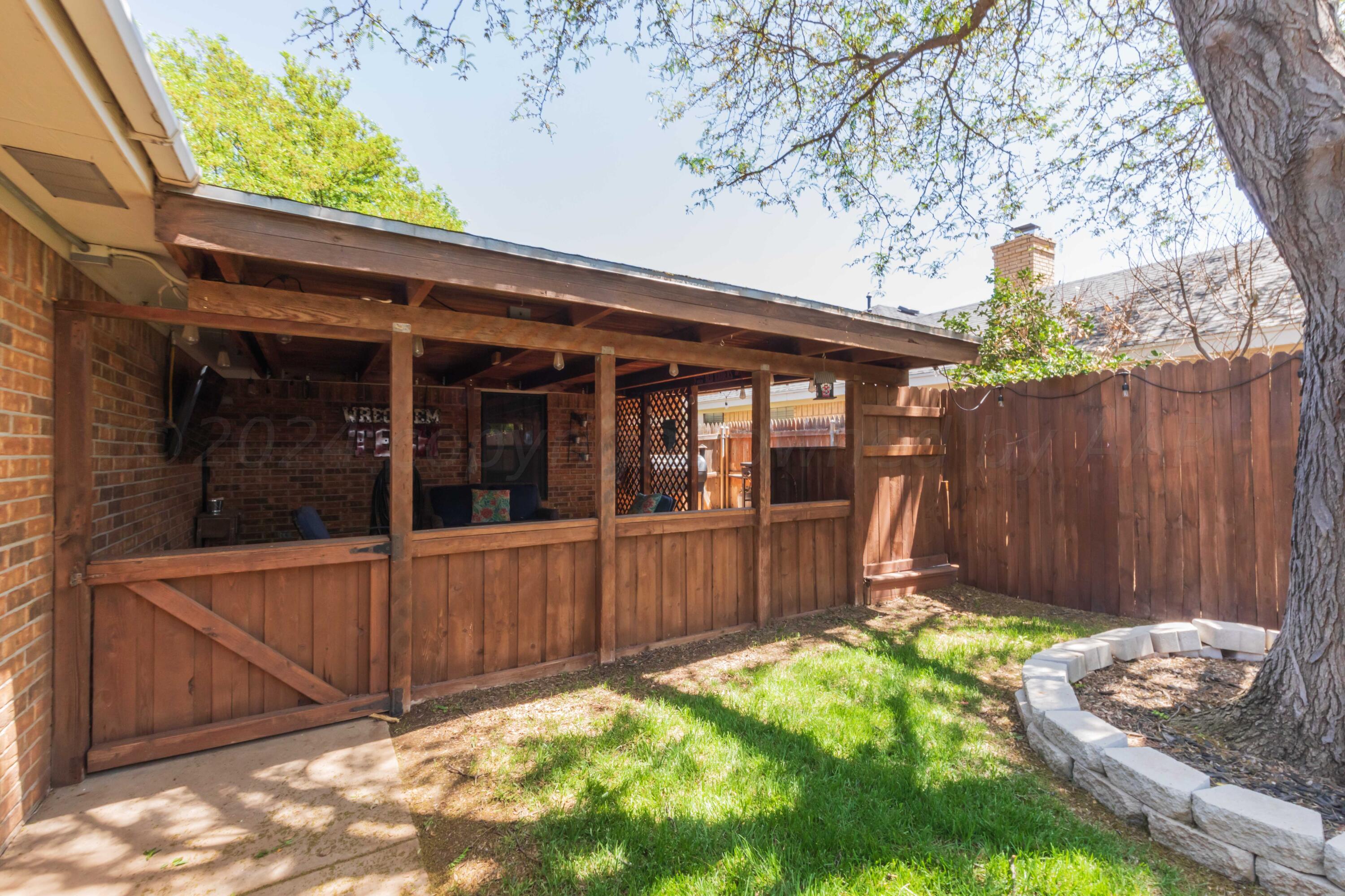 5804 Oakman Drive Amarillo, TX 79109 - Photo 19 of 48 a view of a backyard with table and chairs and wooden fence
