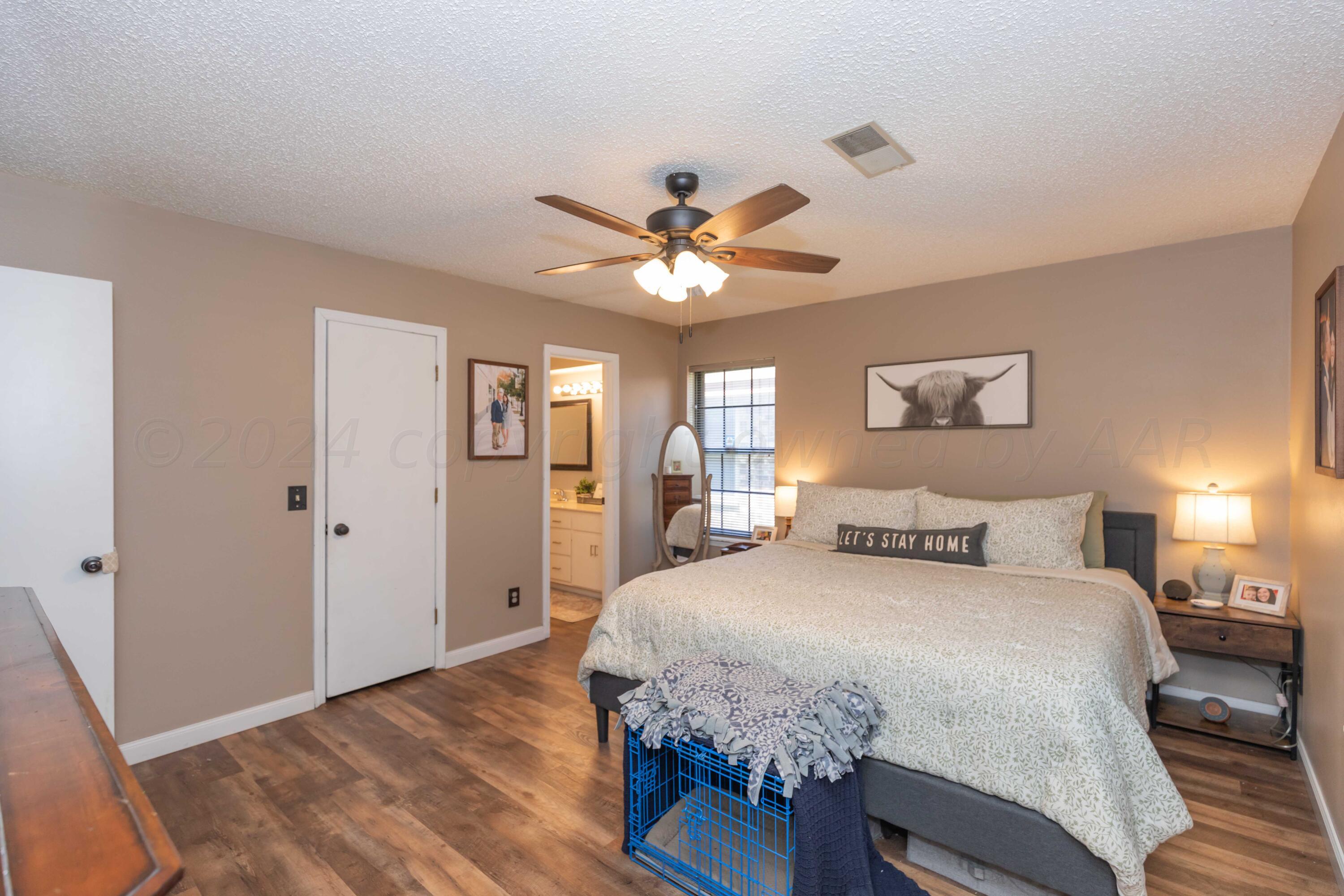 5804 Oakman Drive Amarillo, TX 79109 - Photo 29 of 48 a bedroom with a large bed a chandelier and a chandelier