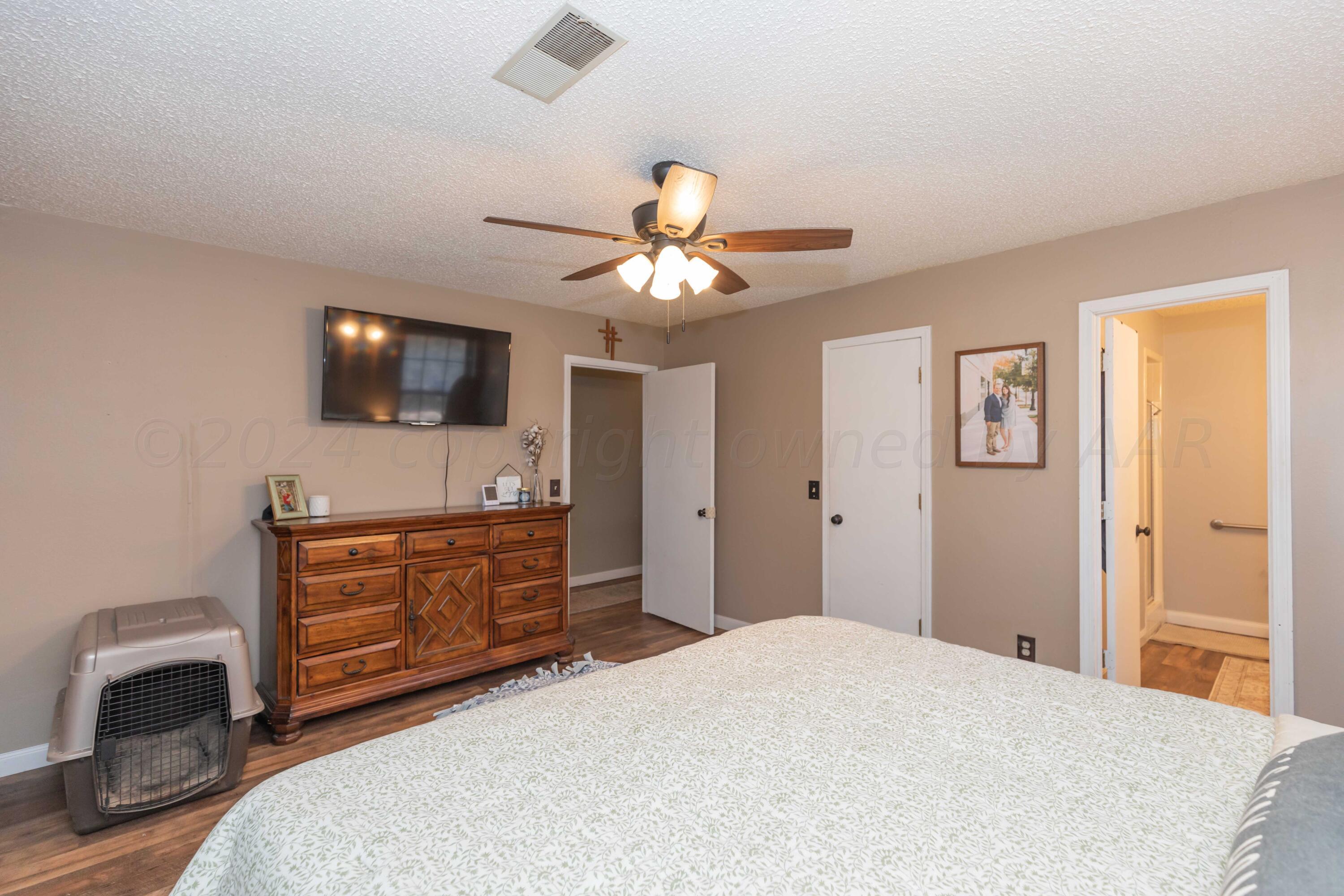 5804 Oakman Drive Amarillo, TX 79109 - Photo 30 of 48 a bedroom with a bed and a flat screen tv