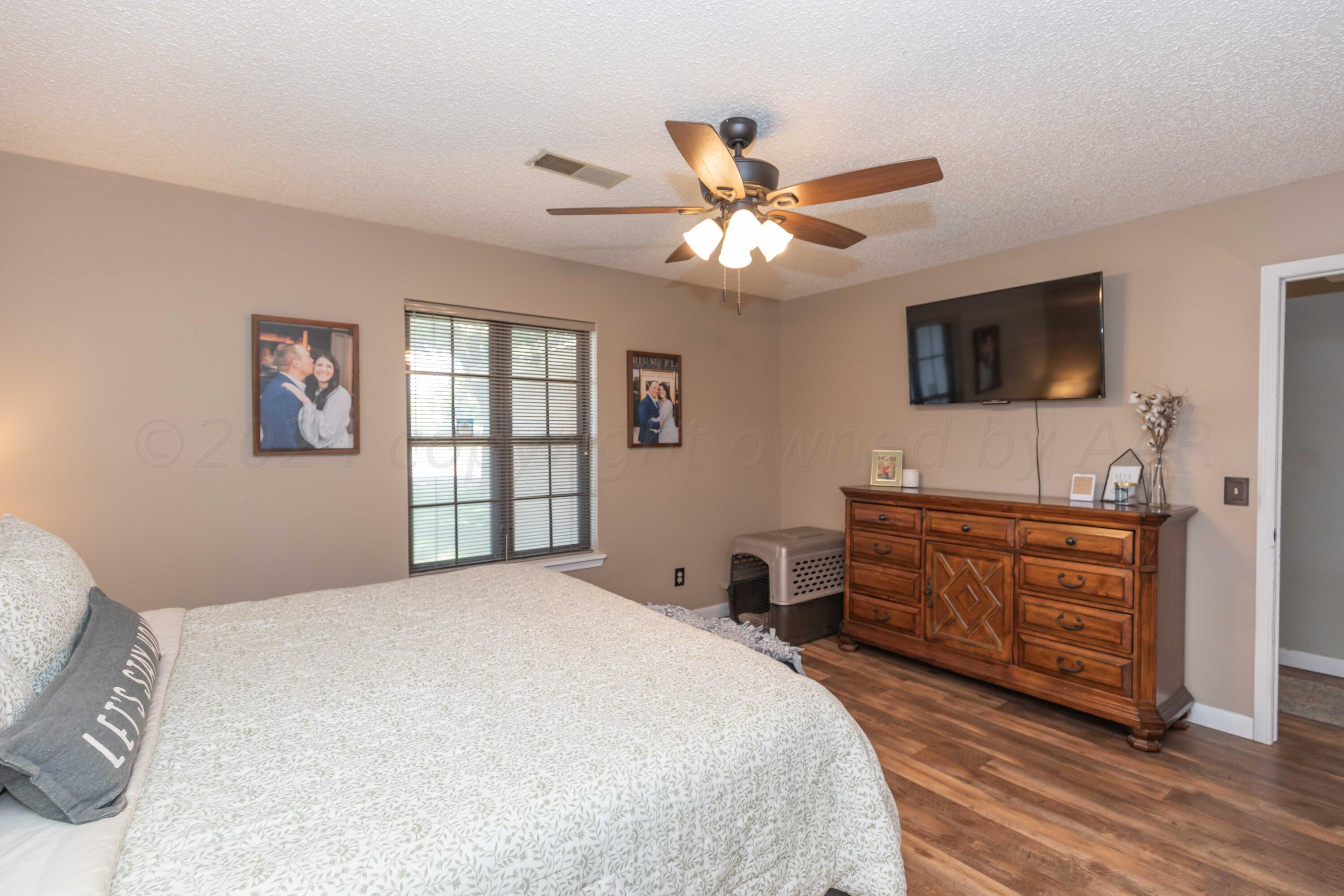 5804 Oakman Drive Amarillo, TX 79109 - Photo 31 of 48 a bedroom with a large bed and a flat screen tv