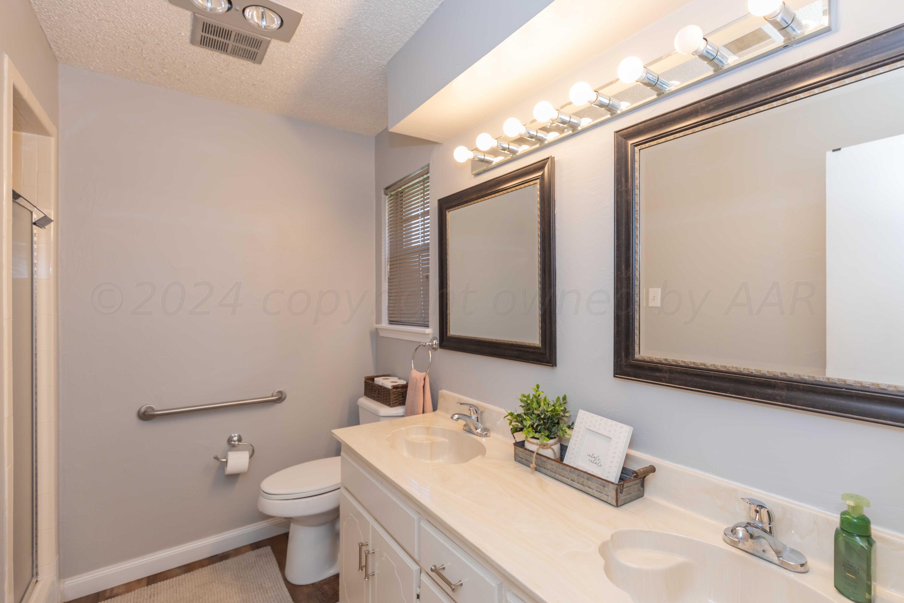 5804 Oakman Drive Amarillo, TX 79109 - Photo 33 of 48 a bathroom with a granite countertop sink mirror and a toilet
