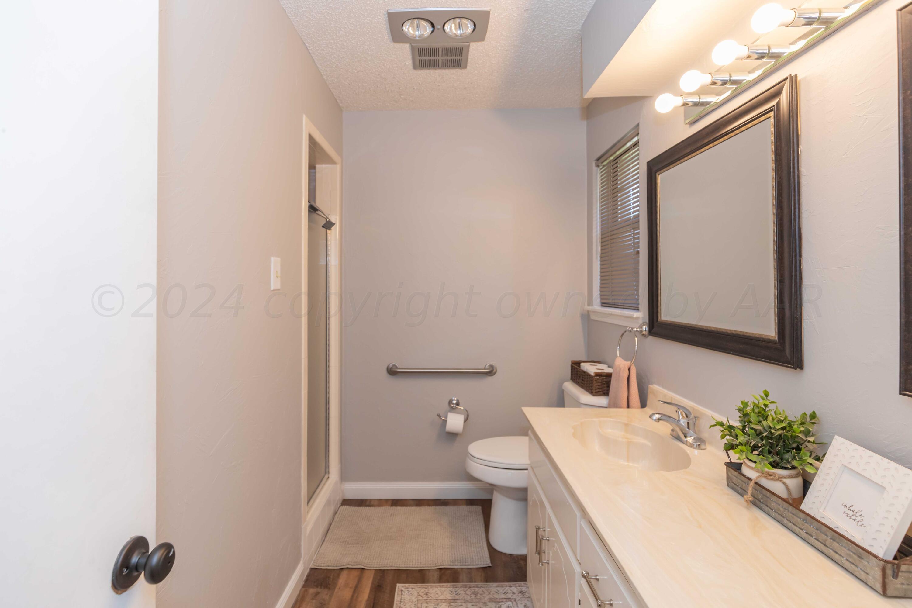 5804 Oakman Drive Amarillo, TX 79109 - Photo 34 of 48 a bathroom with a sink vanity mirror and toilet