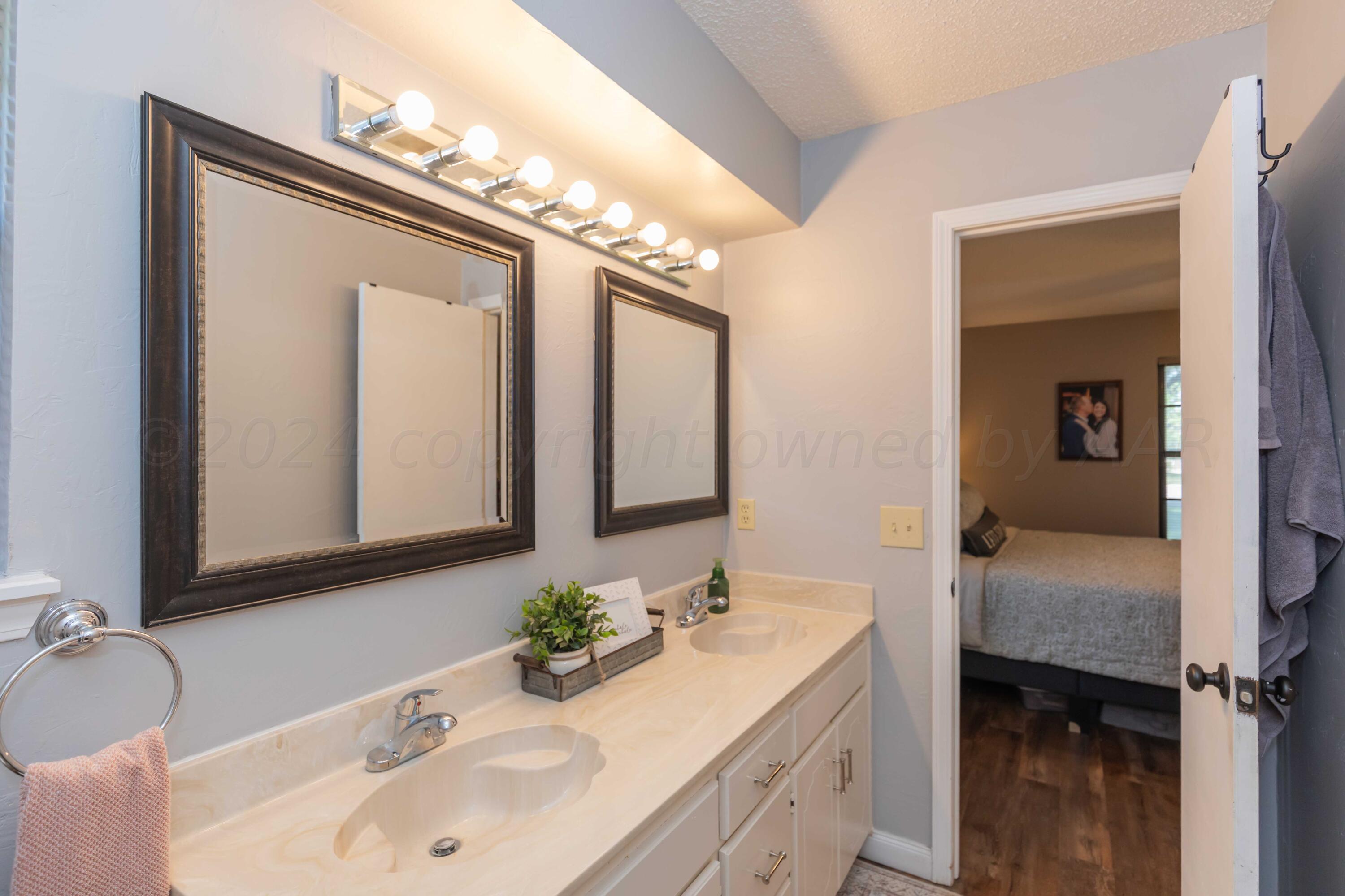 5804 Oakman Drive Amarillo, TX 79109 - Photo 35 of 48 a bathroom with a granite countertop sink and a mirror