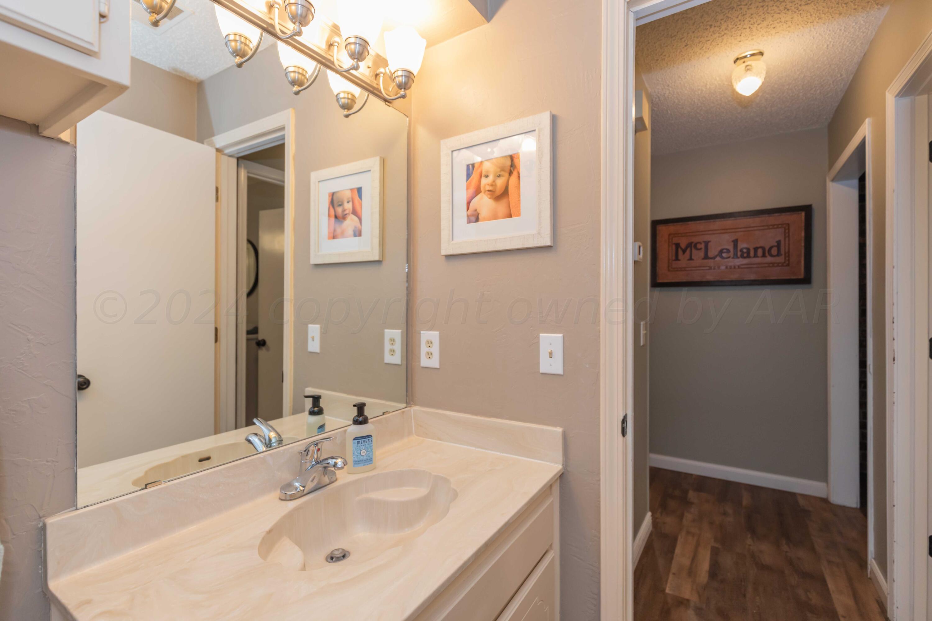 5804 Oakman Drive Amarillo, TX 79109 - Photo 42 of 48 a bathroom with a sink a mirror and a shower