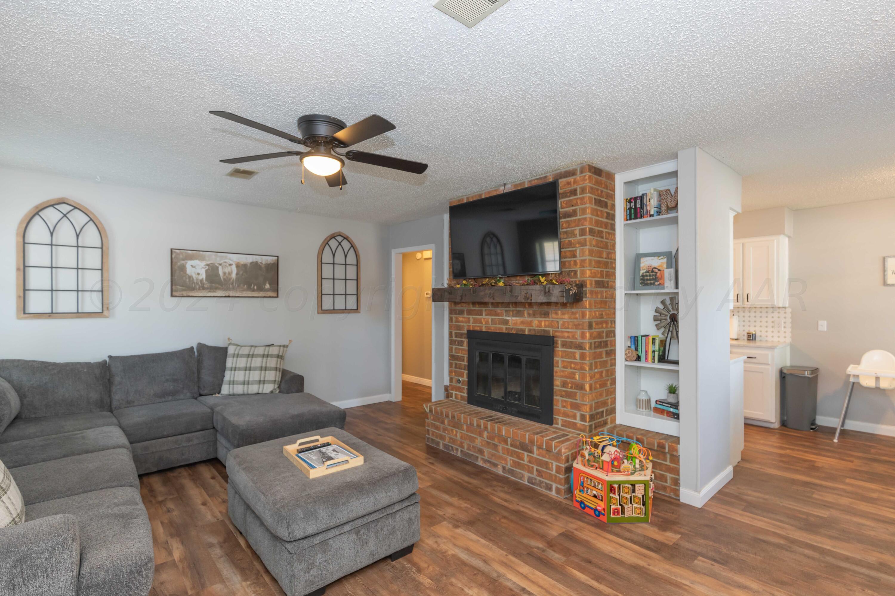5804 Oakman Drive Amarillo, TX 79109 - Photo 7 of 48 a living room with furniture a fireplace and wooden floor