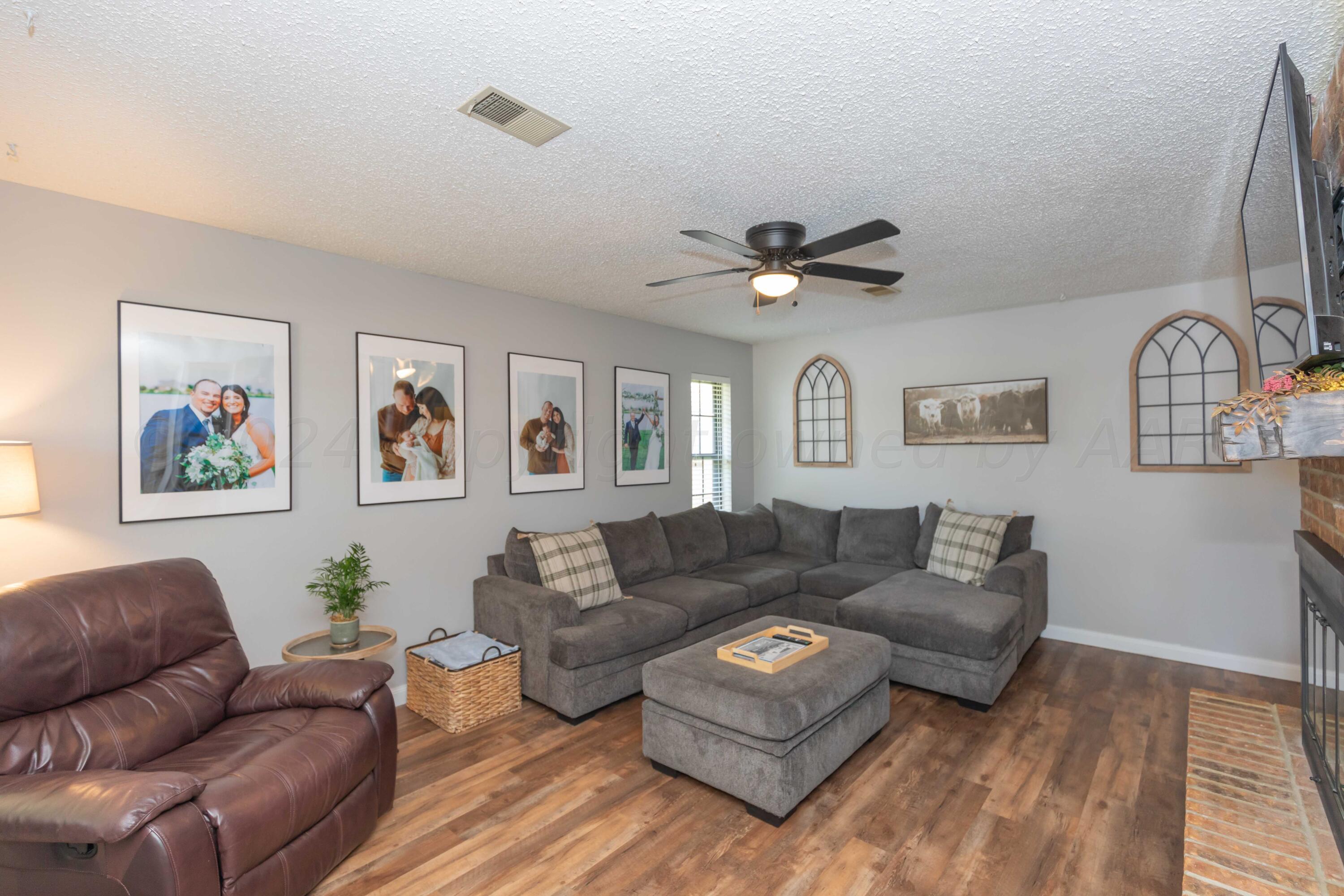 5804 Oakman Drive Amarillo, TX 79109 - Photo 8 of 48 a living room with couches a coffee table and dresser with wooden floor