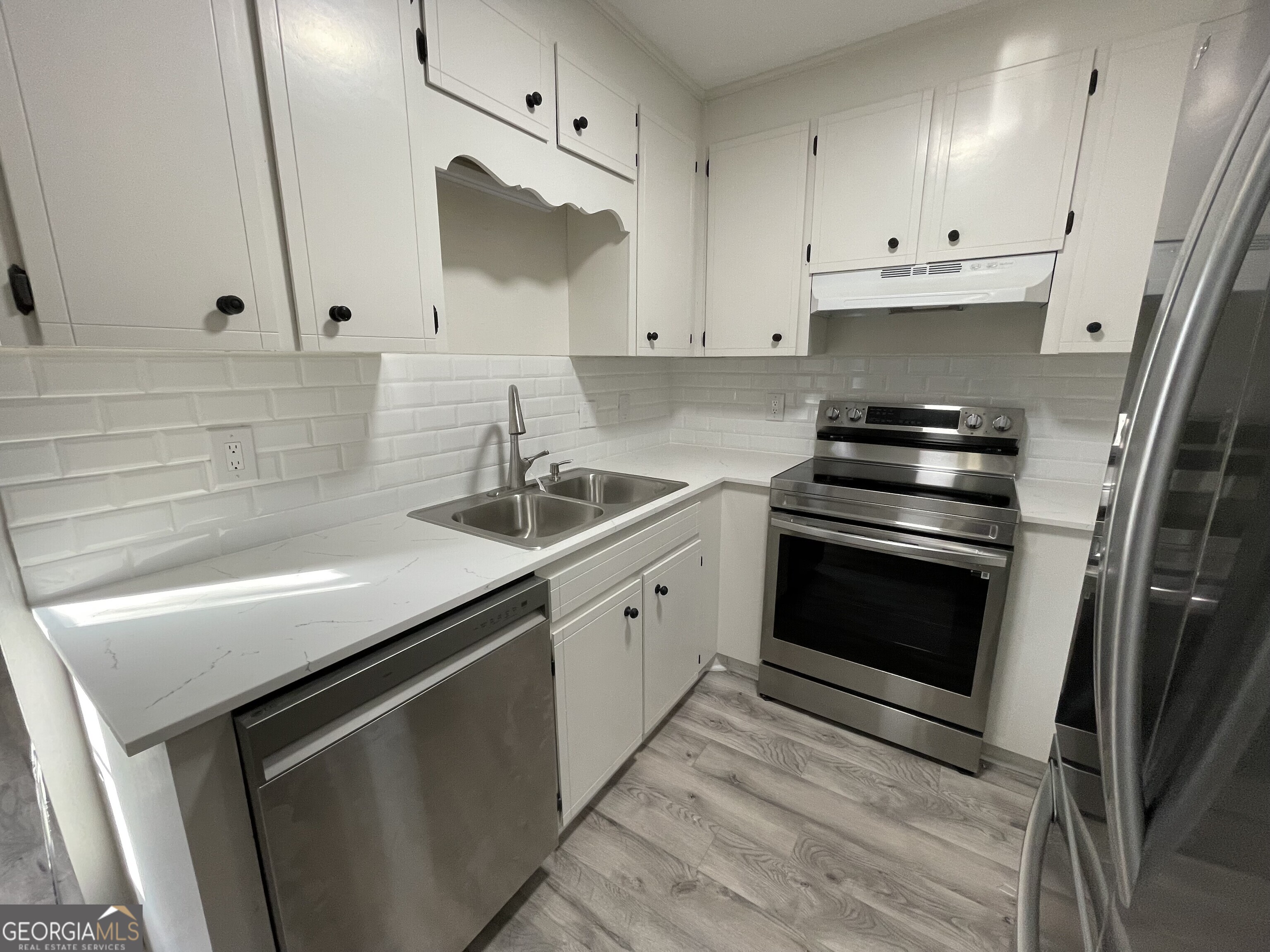 130 Springdale Court Macon, GA 31210 - Photo 4 of 14 a kitchen with white cabinets and appliances