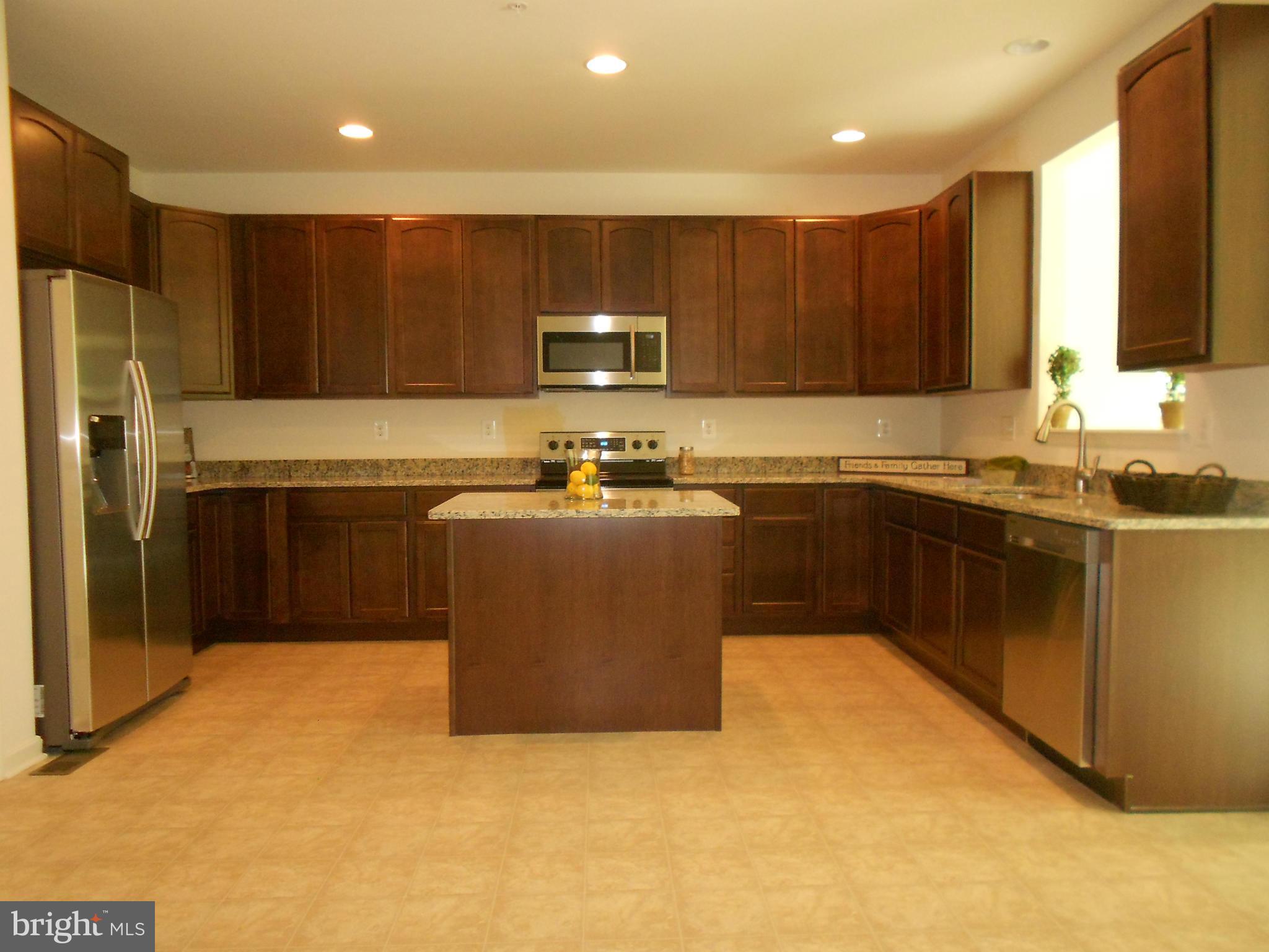 1805 Van Bibber Road Edgewood, MD 21040 - Photo 5 of 30 a kitchen with a sink a stove top oven and wooden cabinets