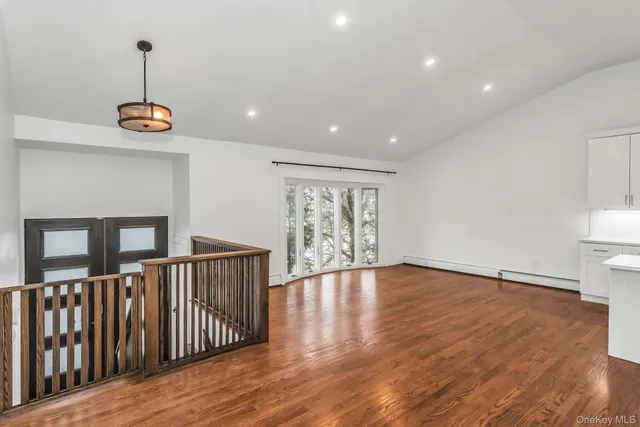 a large kitchen with stainless steel appliances kitchen island granite countertop a sink a stove and a wooden floors