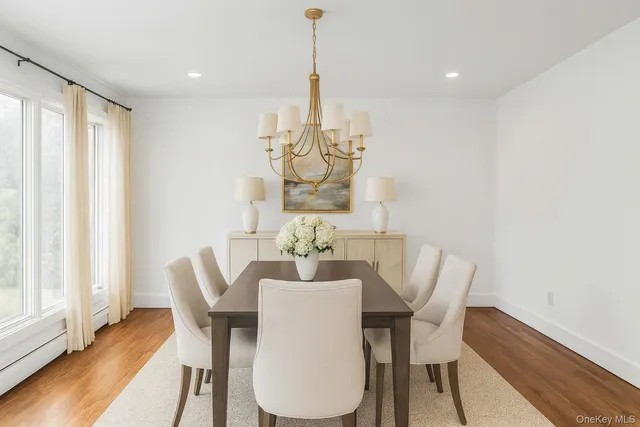 a large kitchen with stainless steel appliances a large counter top a wooden floors and a large window