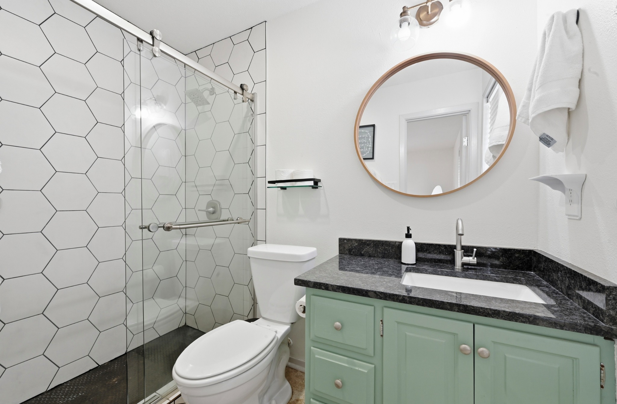 6805 Rearden Road Austin, TX 78745 - Photo 15 of 26 Modern bathroom featuring sleek hexagon tiled shower and a vanity with stone counters.