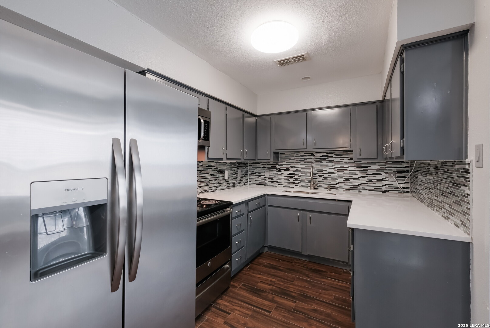 100 Lorenz Road, Unit 804 San Antonio, TX 78209 - Photo 4 of 12 a kitchen with stainless steel appliances granite countertop a refrigerator a sink and wooden cabinets