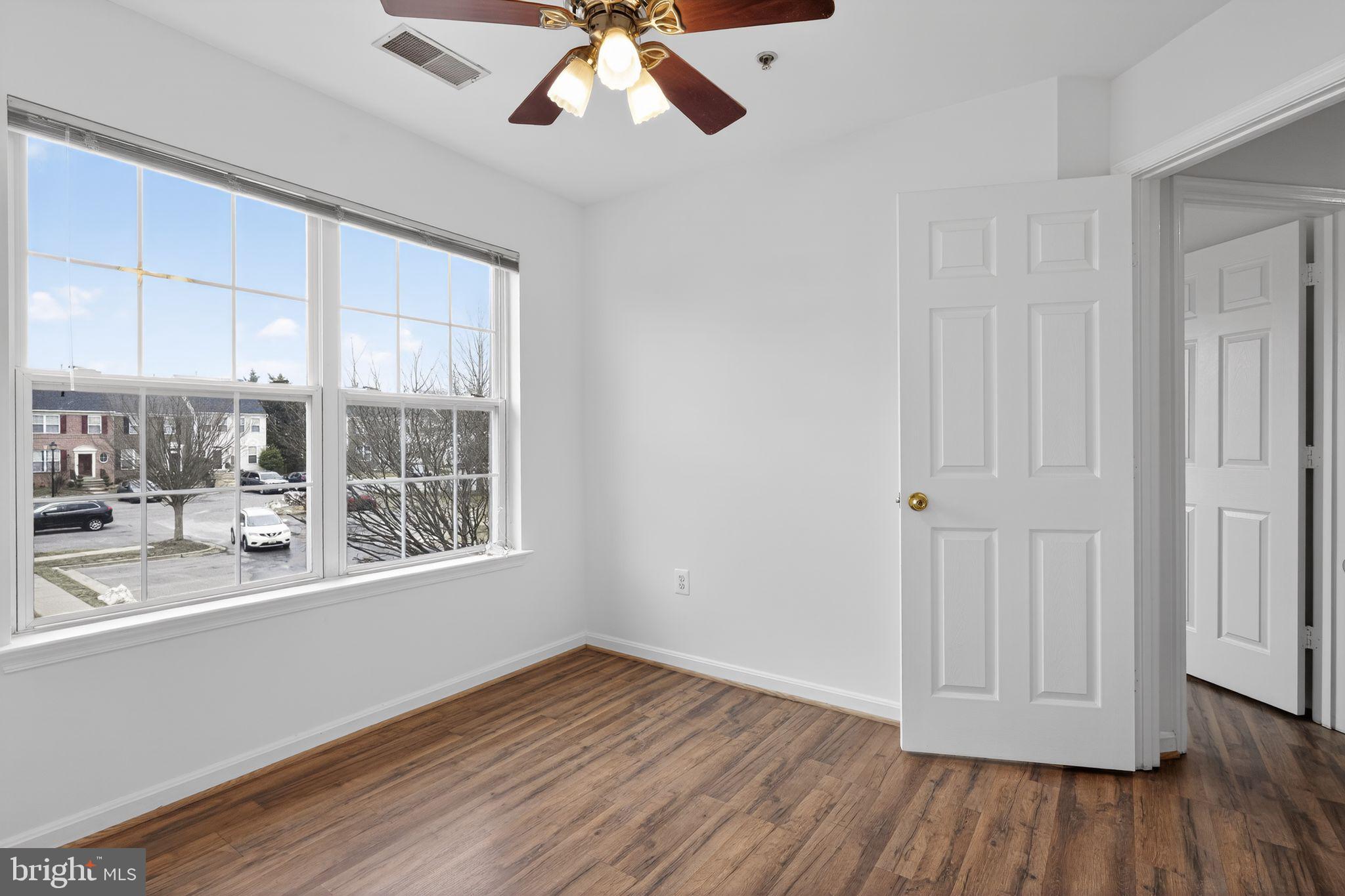 9745 Quiet Brook Lane Clinton, MD 20735 - Photo 13 of 43 an empty room with wooden floor and windows