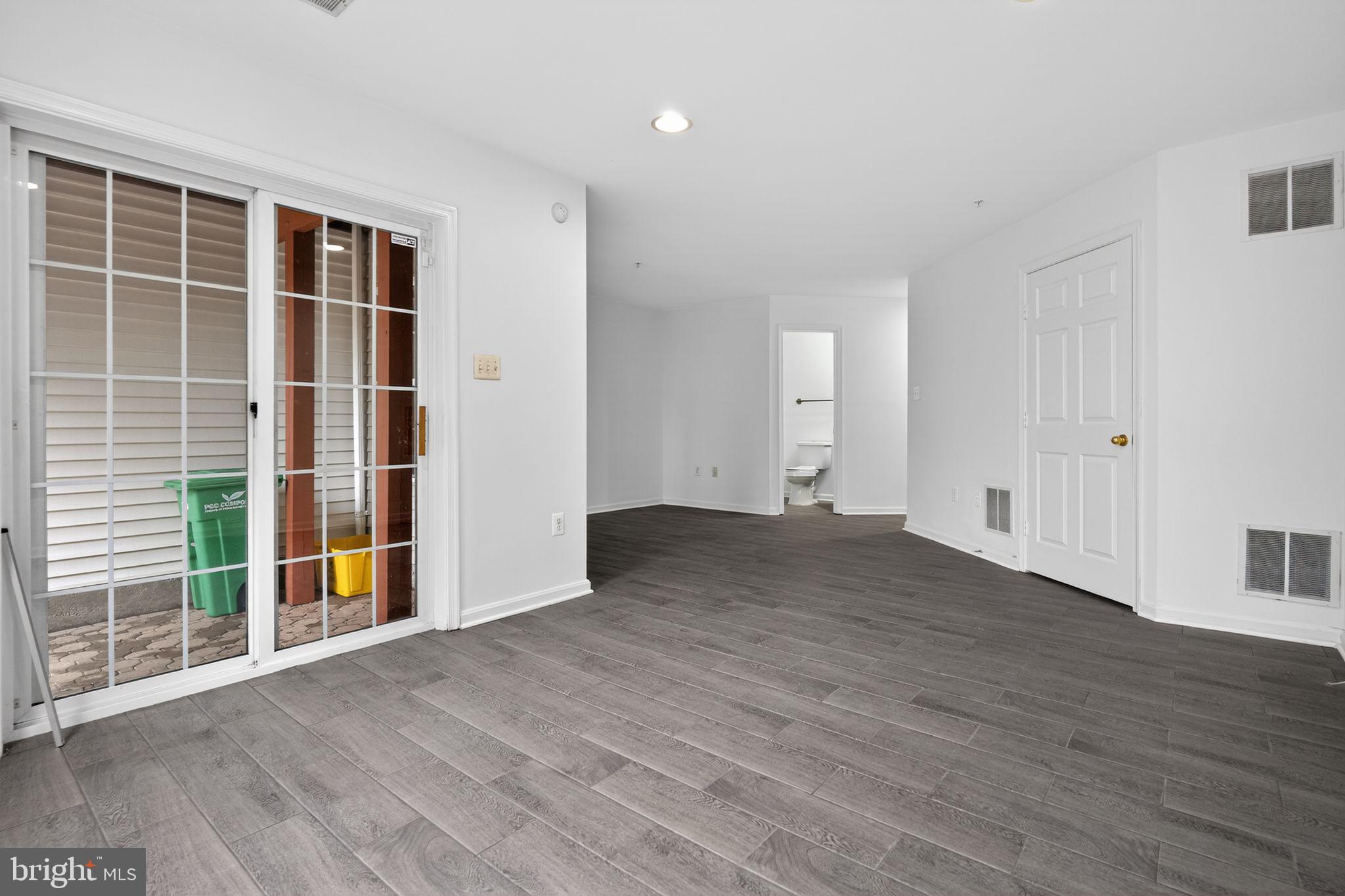 9745 Quiet Brook Lane Clinton, MD 20735 - Photo 15 of 43 an empty room with wooden floor and windows