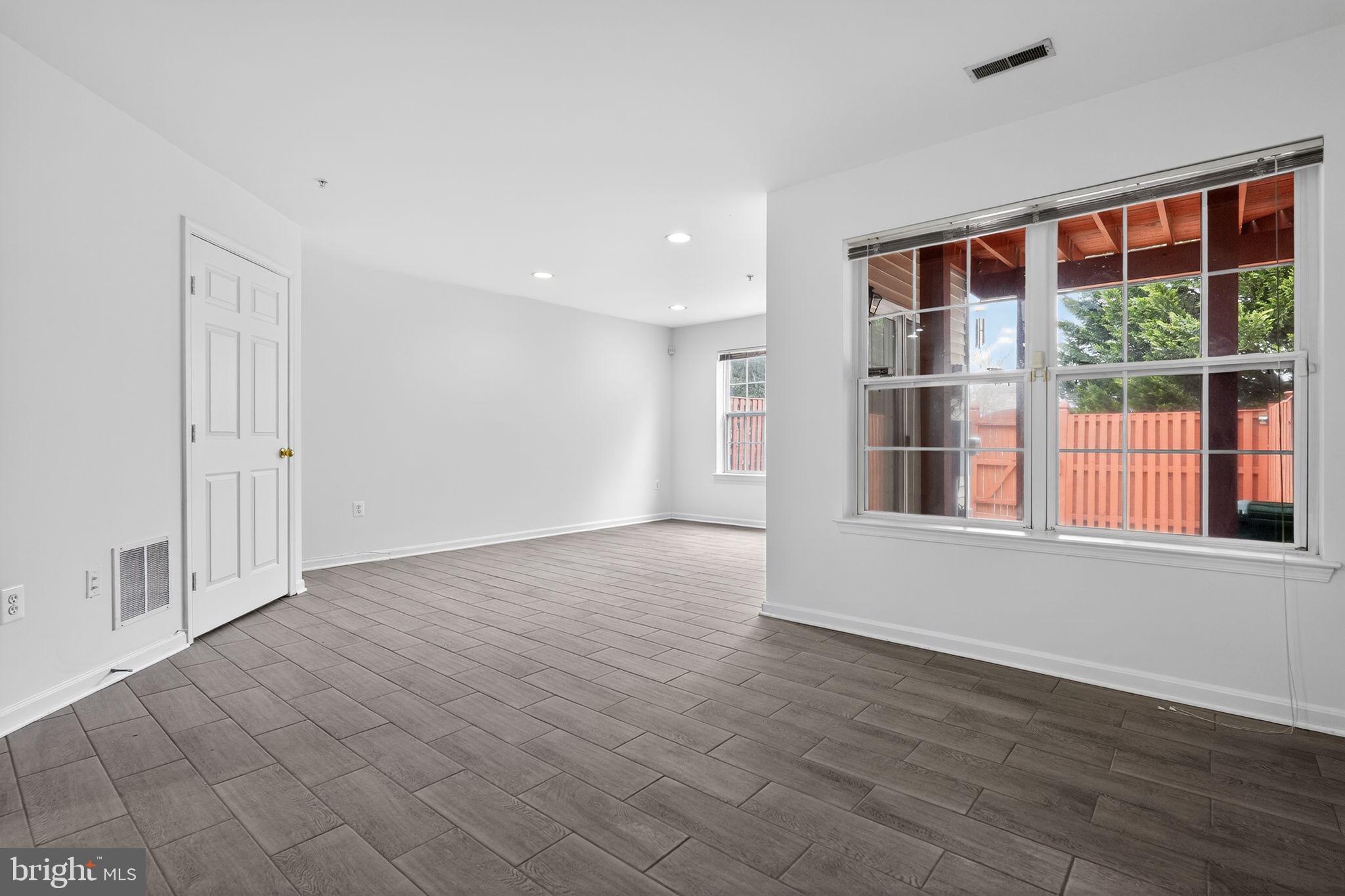9745 Quiet Brook Lane Clinton, MD 20735 - Photo 19 of 43 a view of an empty room with wooden floor and a window