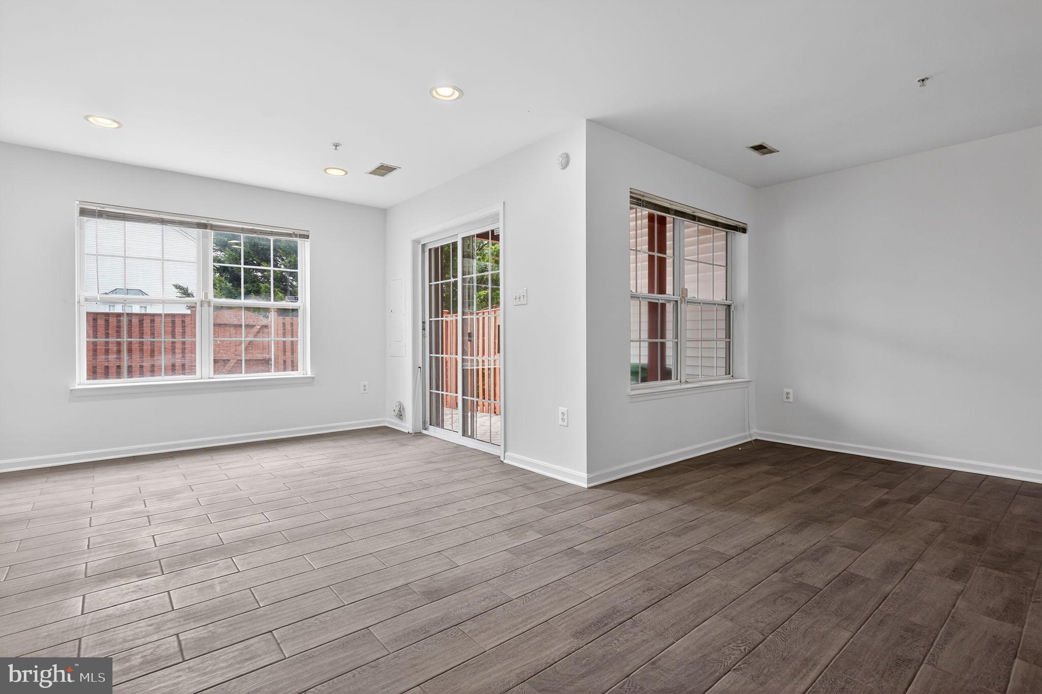 9745 Quiet Brook Lane Clinton, MD 20735 - Photo 21 of 43 a view of an empty room with wooden floor and windows