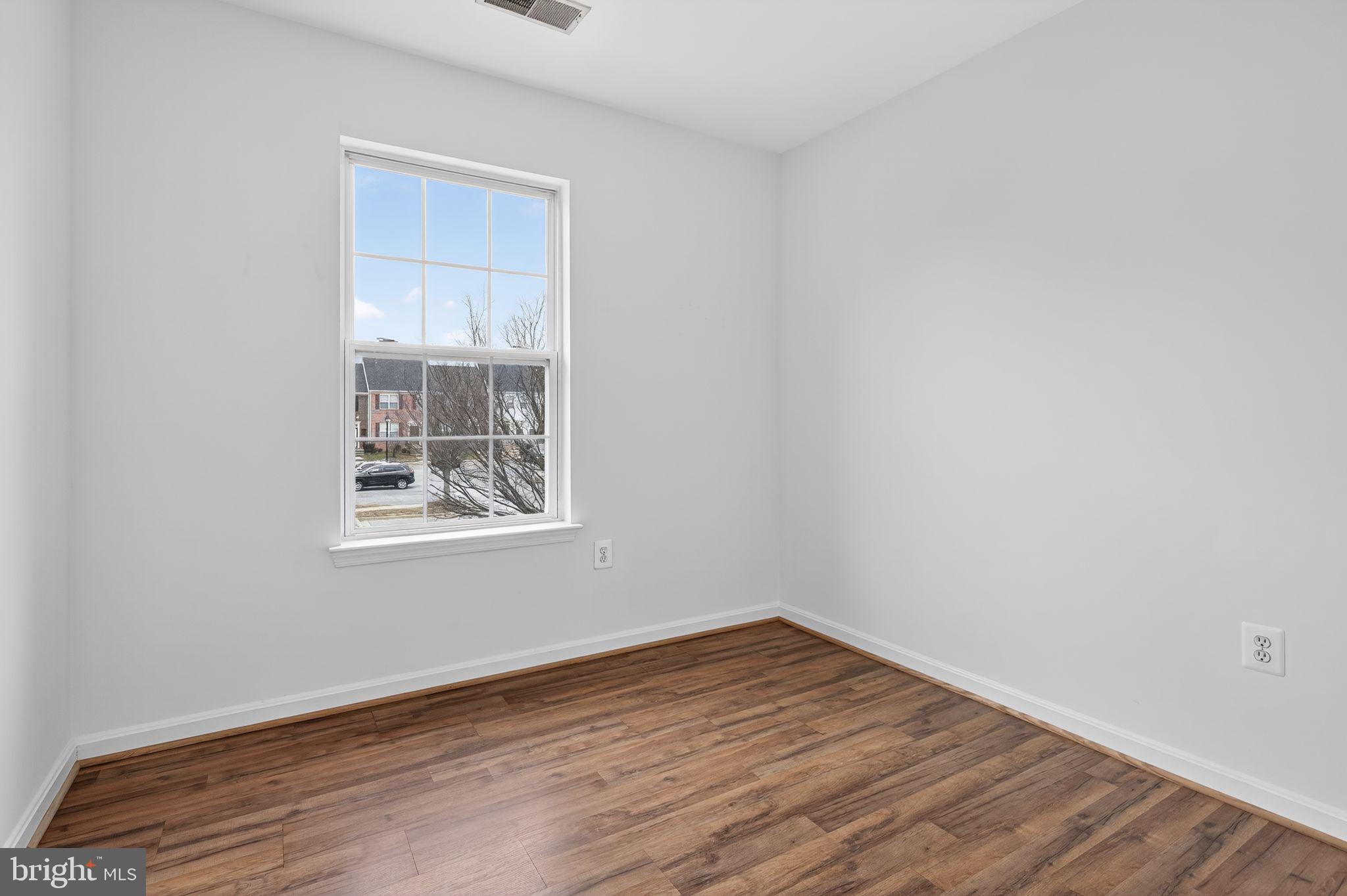 9745 Quiet Brook Lane Clinton, MD 20735 - Photo 22 of 43 an empty room with wooden floor and windows