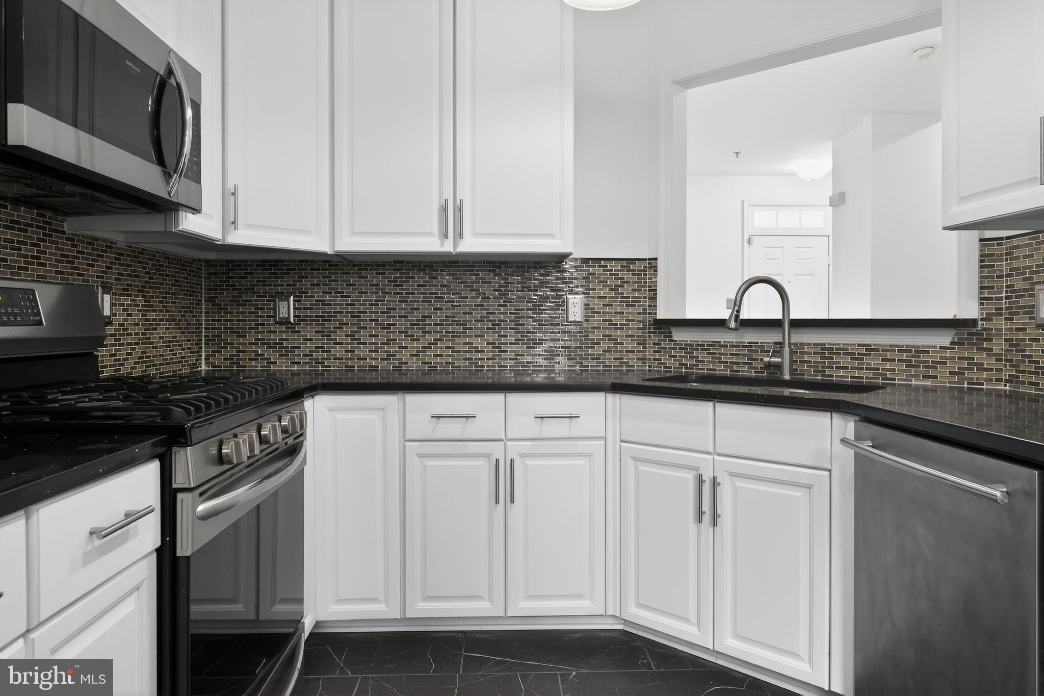 9745 Quiet Brook Lane Clinton, MD 20735 - Photo 23 of 43 a kitchen with granite countertop white cabinets and a stove