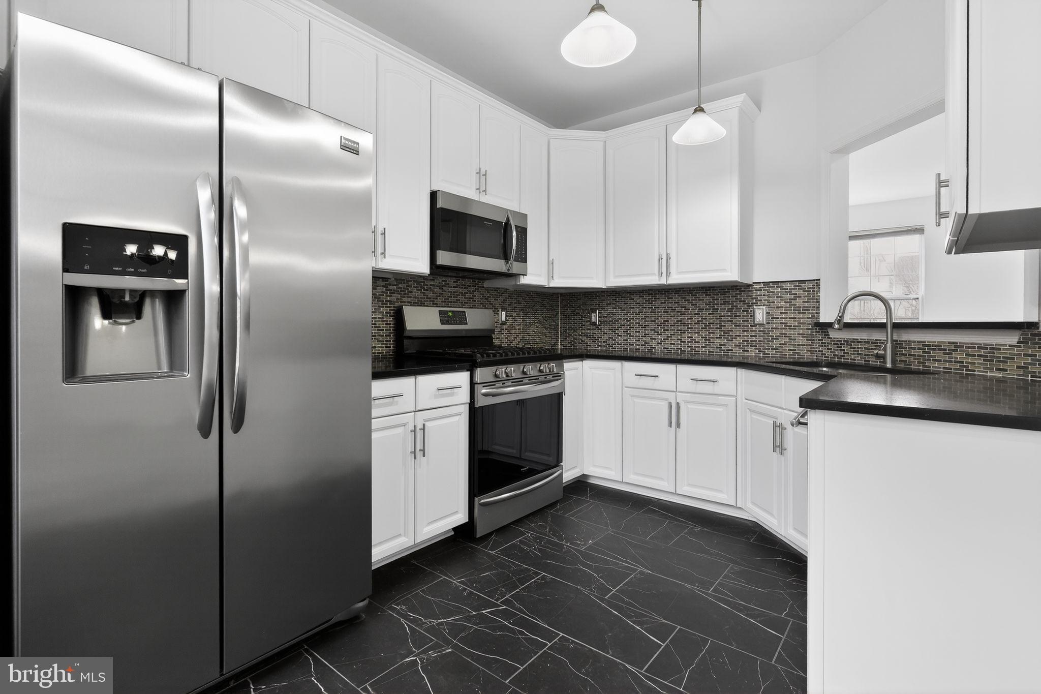 9745 Quiet Brook Lane Clinton, MD 20735 - Photo 24 of 43 a white kitchen with granite countertop stainless steel appliances
