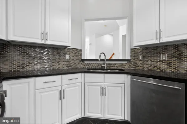 a sink with white cabinets