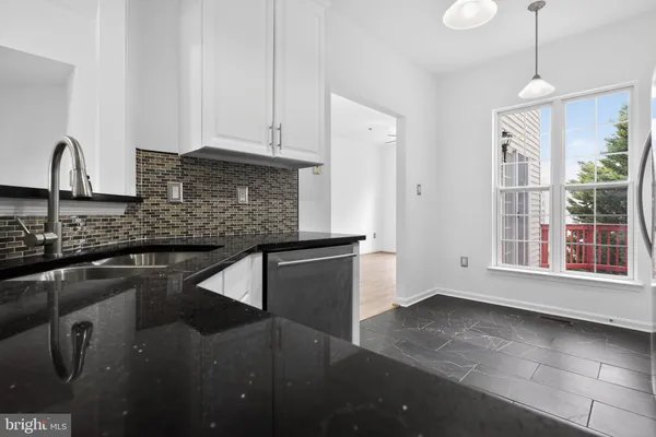 a kitchen with stainless steel appliances granite countertop a sink a stove and a refrigerator