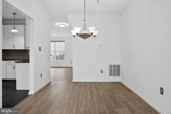 a view of a room with wooden floor and a ceiling fan