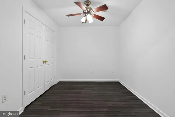 a view of room with hardwood floor and a ceiling fan