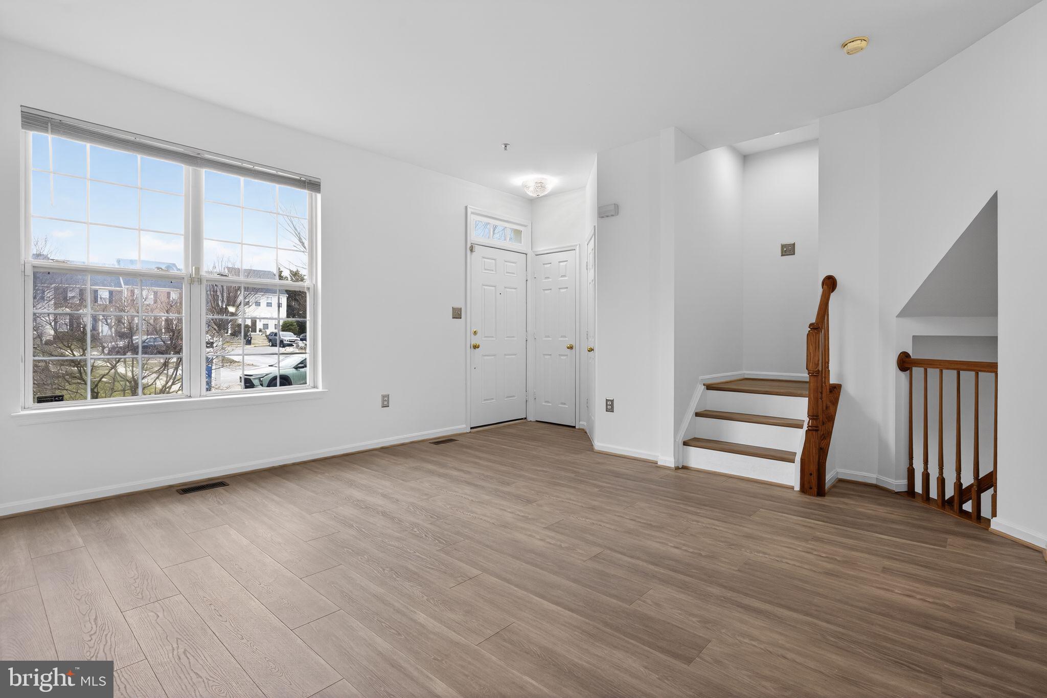 9745 Quiet Brook Lane Clinton, MD 20735 - Photo 10 of 43 a view of an empty room with wooden floor and a window