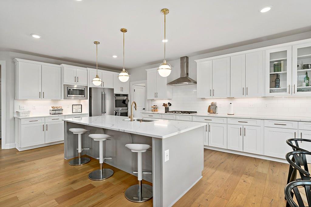 105 Abigail Drive Mars, PA 16046 - Photo 20 of 50 a kitchen with stainless steel appliances granite countertop a sink a stove a refrigerator and island with wooden floor