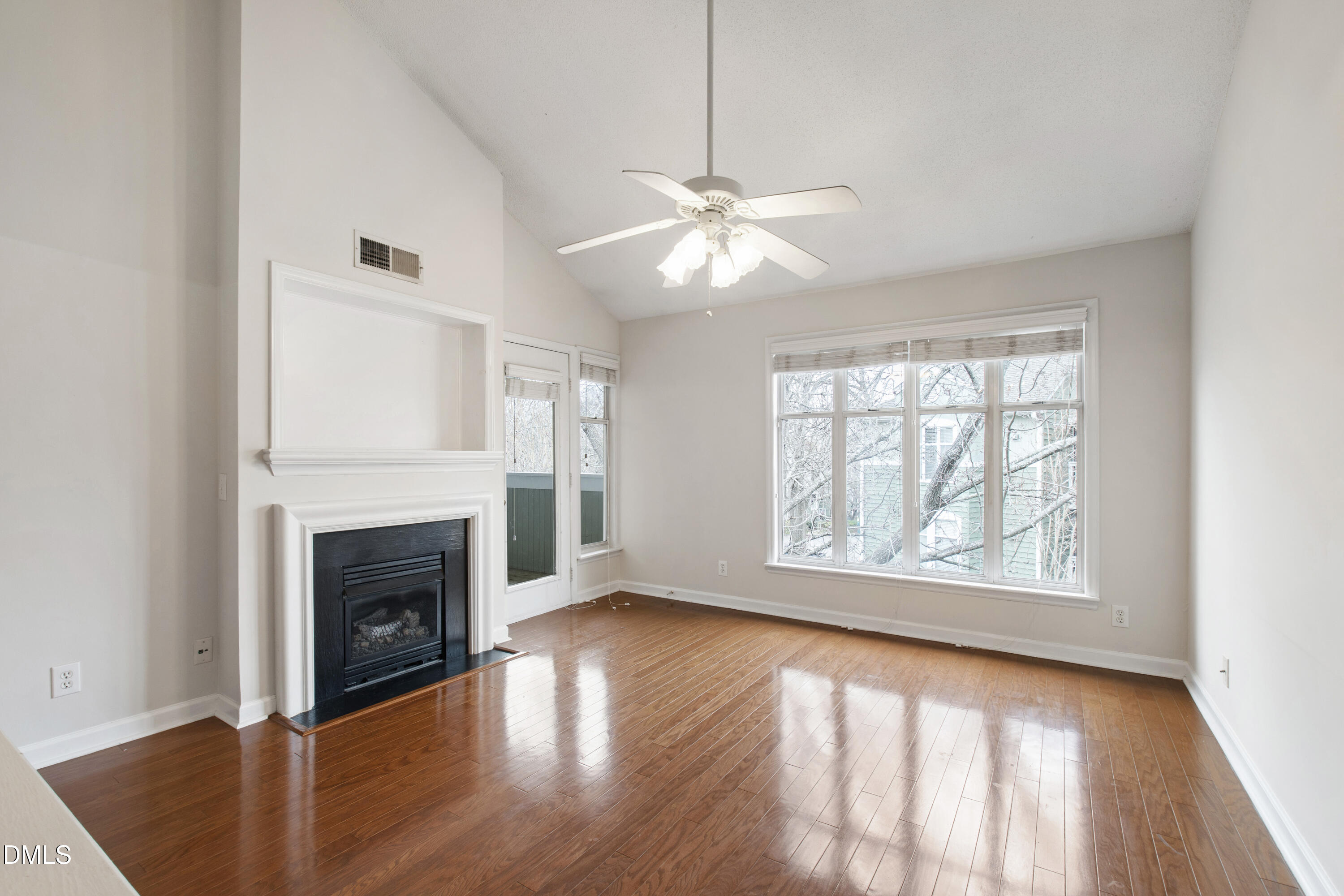 1210 Westview Lane, Unit 303 Raleigh, NC 27605 - Photo 3 of 27 an empty room with windows fireplace and wooden floor