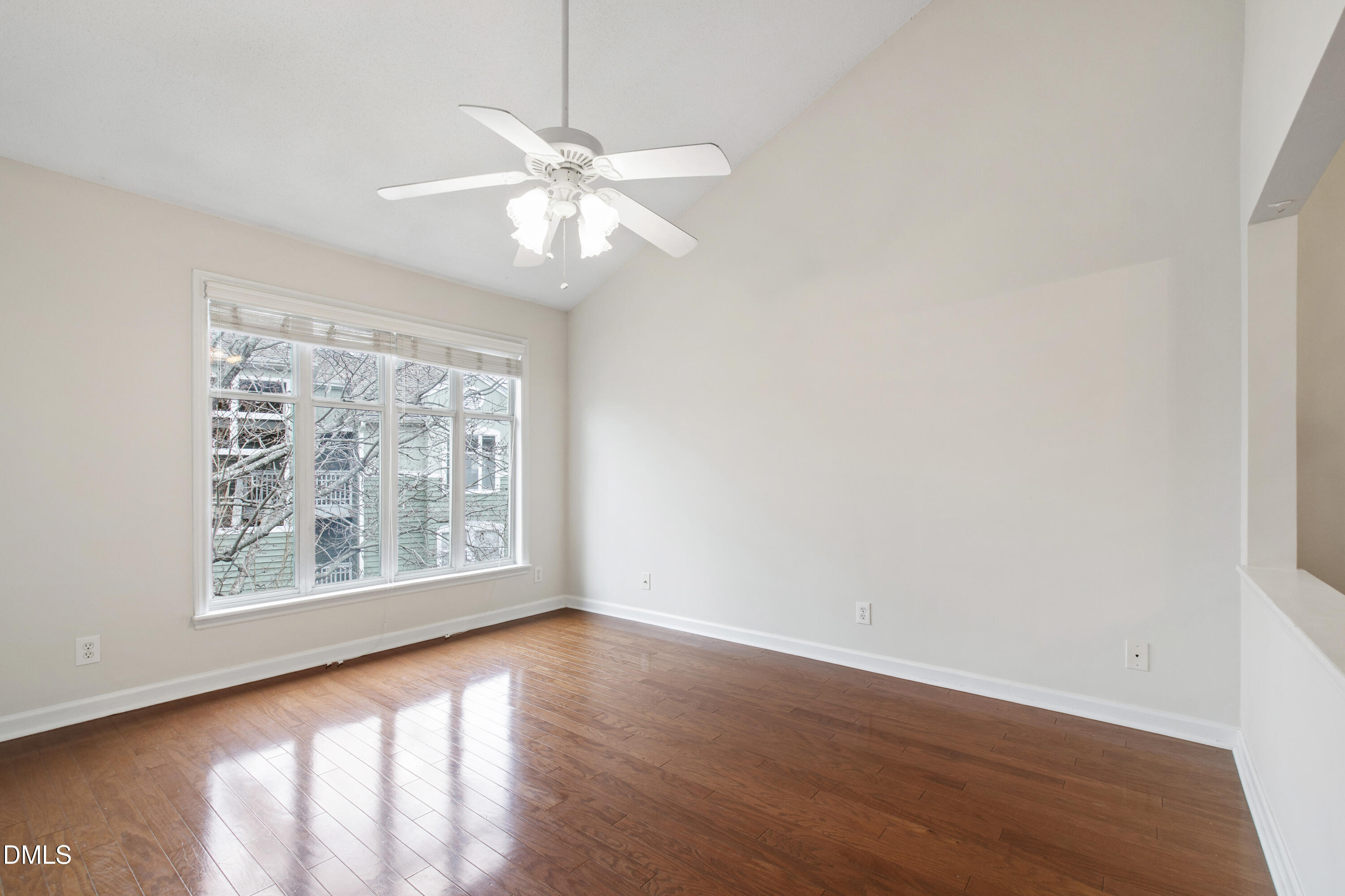 1210 Westview Lane, Unit 303 Raleigh, NC 27605 - Photo 4 of 27 an empty room with wooden floor chandelier fan and windows