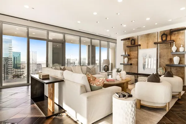 a living room with furniture and a floor to ceiling window