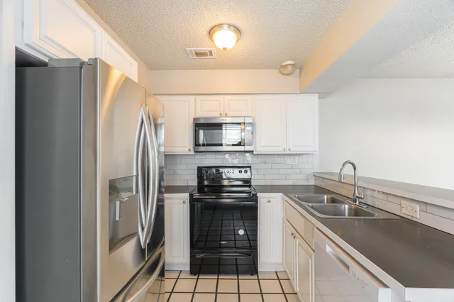 a kitchen with stainless steel appliances a refrigerator sink and microwave