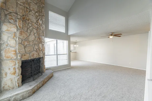 an empty room with windows and fireplace
