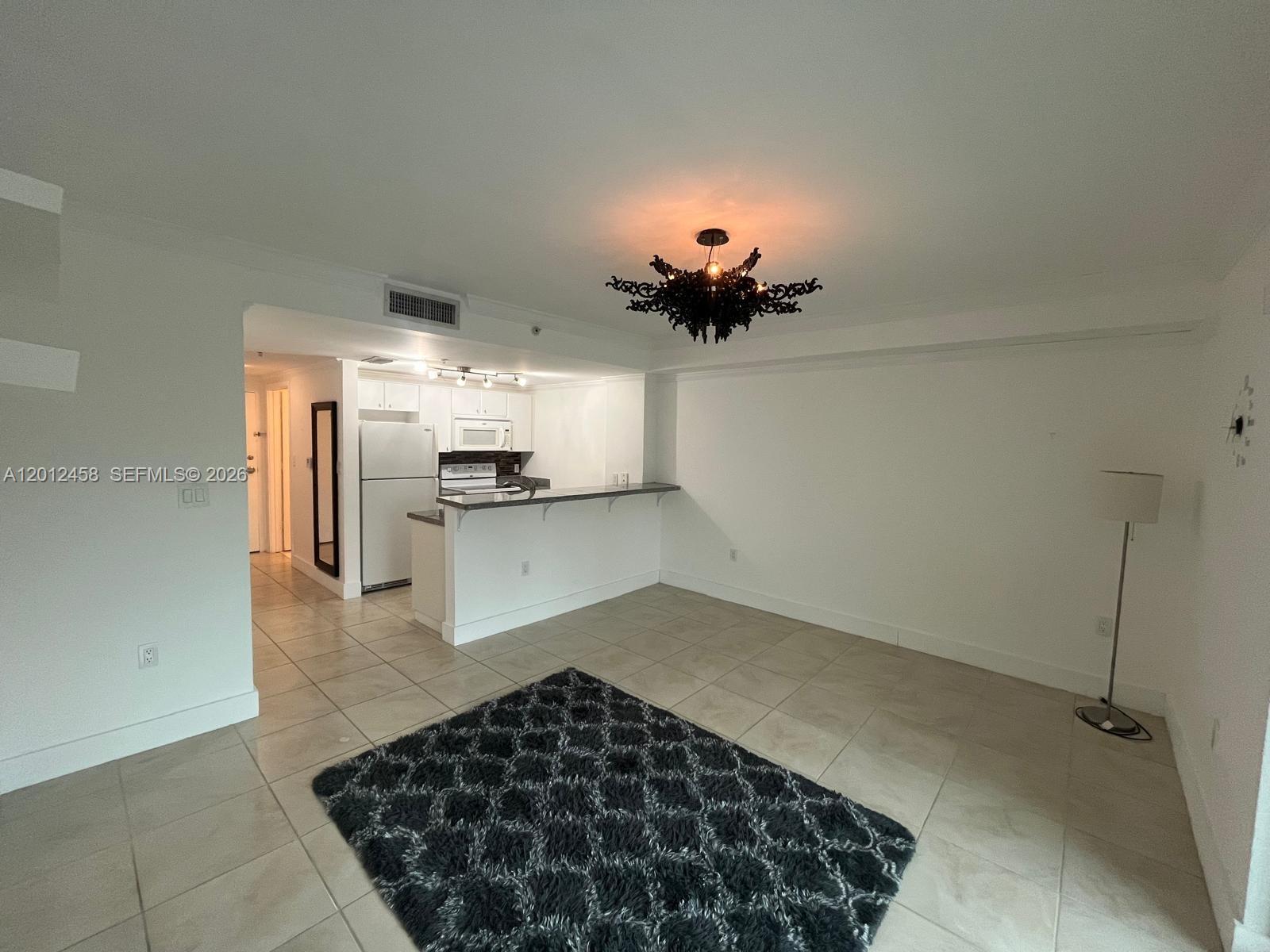 2740 Southwest 28th Terrace, Unit 203 Miami, FL 33133 - Photo 13 of 14 a kitchen with granite countertop a sink and cabinets