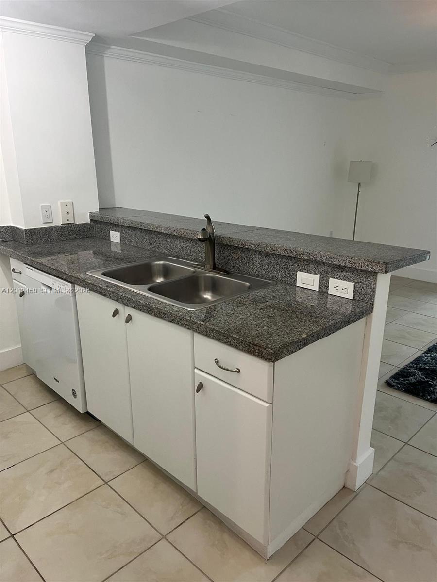 2740 Southwest 28th Terrace, Unit 203 Miami, FL 33133 - Photo 10 of 14 a kitchen with granite countertop a sink and a stove