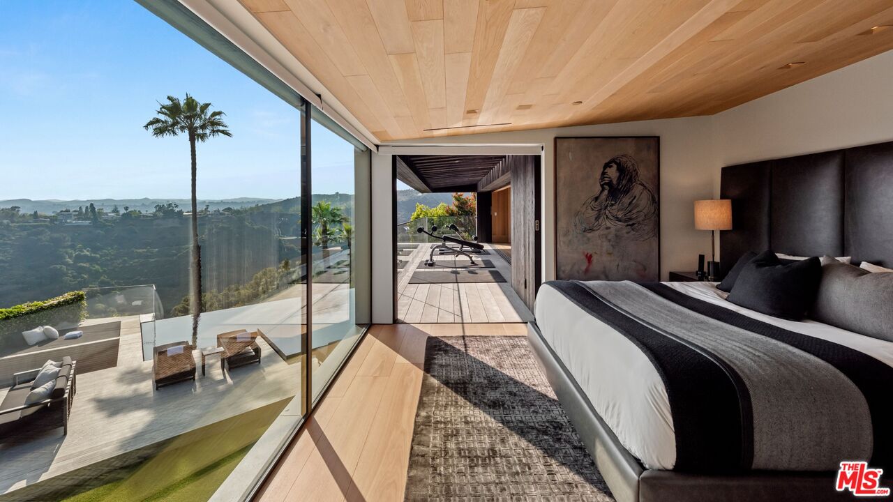 1663 Summitridge Drive Beverly Hills, CA 90210 - Photo 32 of 41 a bedroom with a bed and large windows