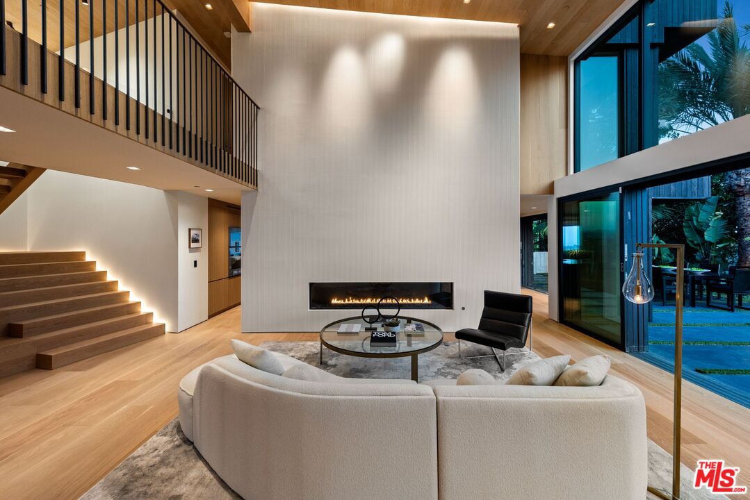 1663 Summitridge Drive Beverly Hills, CA 90210 - Photo 6 of 41 a living room with furniture and a floor to ceiling window