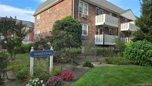 a front view of a house with a garden and plants
