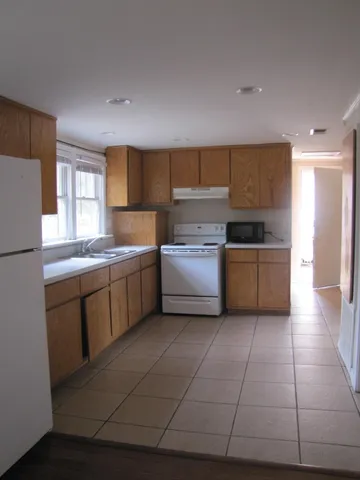 a kitchen with a sink a stove and cabinets
