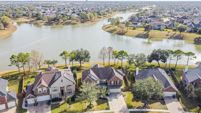 an aerial view of residential houses with outdoor space and lake view