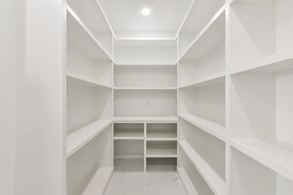a view of walk in closet with empty racks