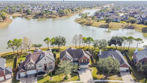 an aerial view of residential houses with outdoor space and lake view