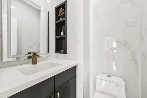 a bathroom with a sink a toilet and shower