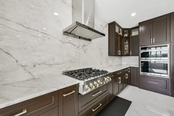 a kitchen with stainless steel appliances granite countertop a stove and a refrigerator
