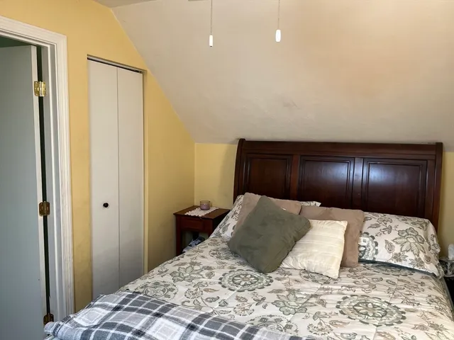 a large bedroom with a bed and lamp